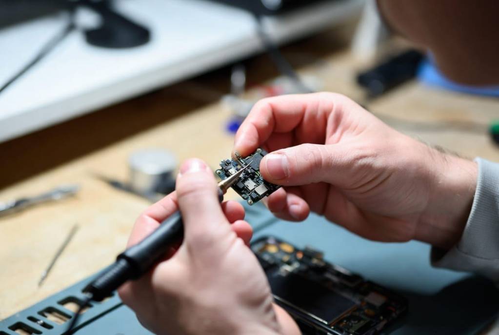 iPhone Data Recovery 2 Precision micro-soldering on a phone logic board under the microscope
