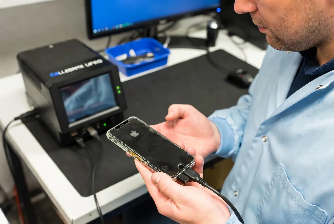 Digital forensics examiner connecting an iPhone to a Cellebrite UFED extraction unit in the Wildfire Brisbane laboratory